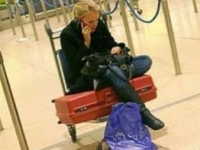 Британка звонит по мобильному телефону в аэропорту Хитроу.